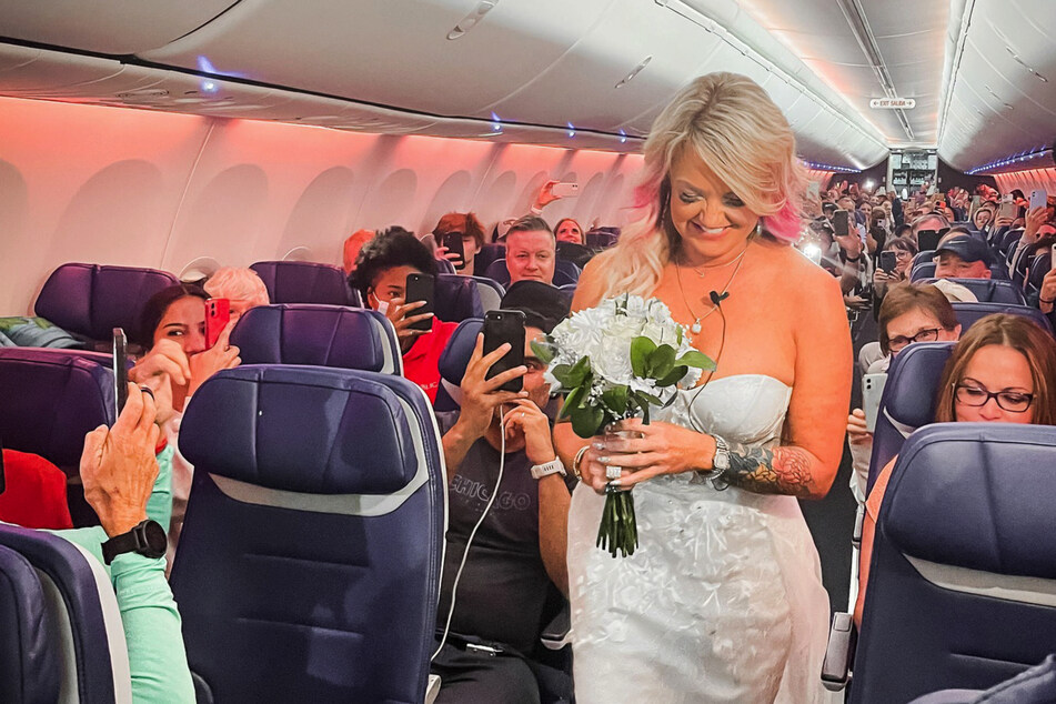 Glücklich schritt die Braut den Gang des Flugzeuges entlang.