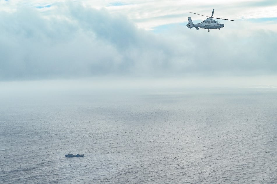 An aircraft identified by the Philippine Coast Guard as Chinese Navy helicopter flies near the Scarborough Shoal in the South China Sea.