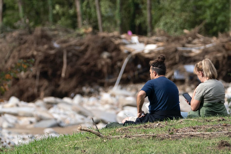 People look out over flood damage in the aftermath of Hurricane Helene on Wednesday in Bat Cave, North Carolina. The death toll has topped 200 people across the southeastern US due to the storm, according to published reports, which made landfall as a category 4 storm on Thursday.