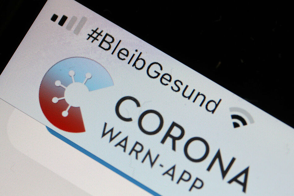 Die Corona-Warn-App mit der Seite zur Risiko-Ermittlung ist im Display eines Smartphone zu sehen.