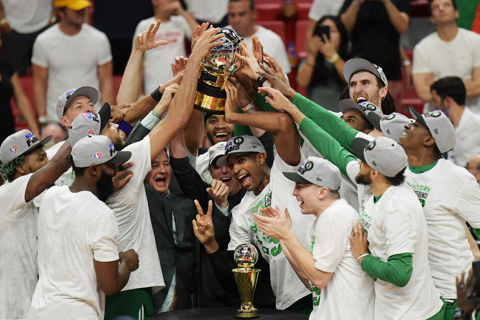 The Celtics lift the Bob Cousy Trophy as champions of the Eastern Conference.