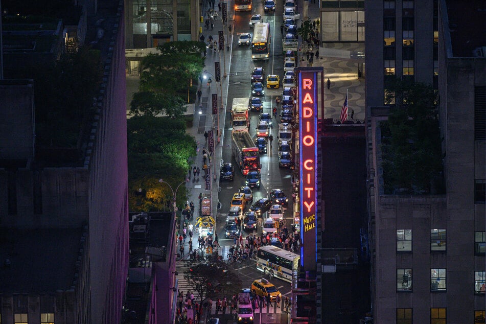 Traffic makes its way past Radio City along a cross-street in Manhattan, New York city on September 22, 2022.