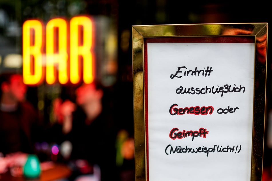 Vor einer Hamburger Bar steht ein Hinweisschild, das auf den Einlass nach der 2G-Regel hinweist. Ein Barbesitzer hat wegen dieser Regel nun eine Bombendrohung bekommen. (Symbolfoto)