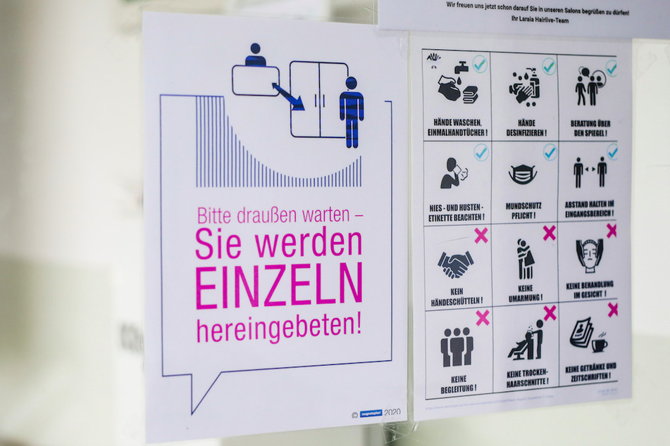 Ein Schild weist Kunden in einem Friseursalon über die neu geltenden Regeln im Salon aufgrund der Corona-Pandemie hin.