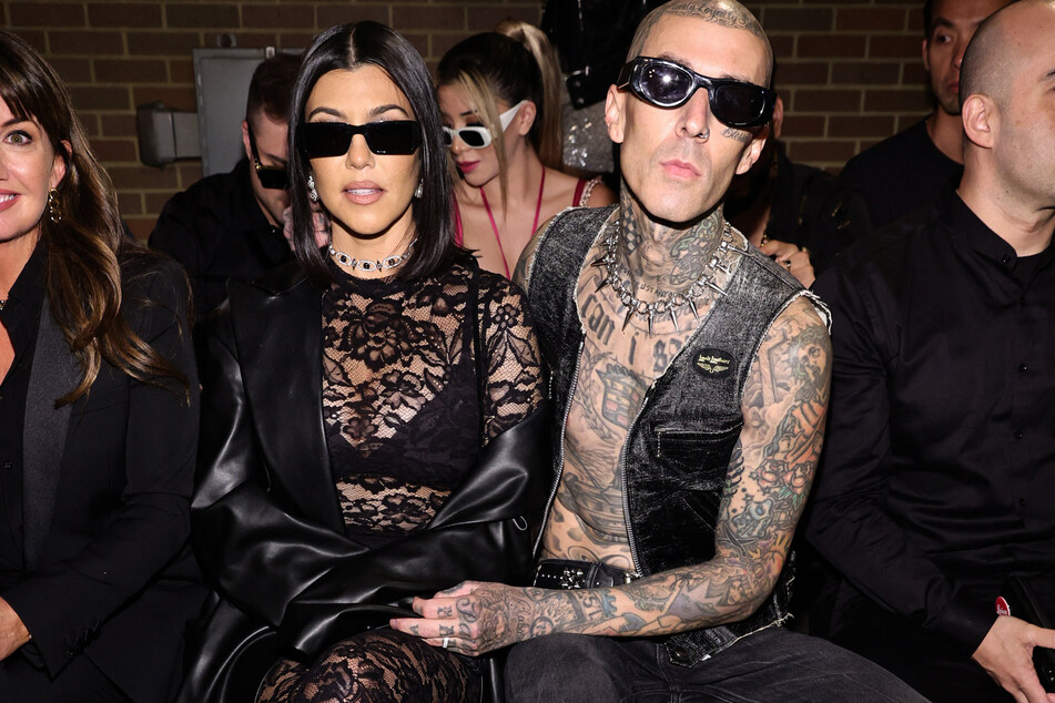 Kourtney Kardashian Barker and Travis Barker strike a pose while sitting front row at NYFW.