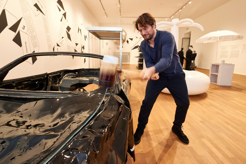 Ist das Kunst oder muss da noch eine Beule rein? Friedrich von Borries, Kurator und Initiator der Ausstellung "Schule der Folgenlosigkeit" im Museum für Kunst und Gewerbe Hamburg (MK&G), schlägt mit einem Hammer auf einen Porsche ein.