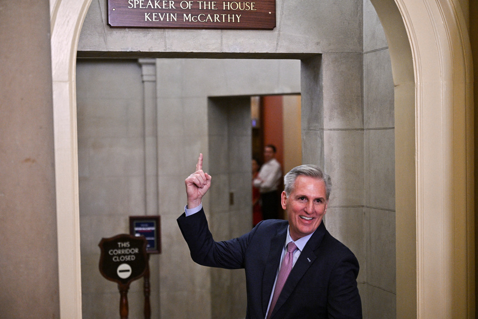 New US Speaker of the House Kevin McCarthy points up to his plaque just mounted over the door to the Speaker's office.