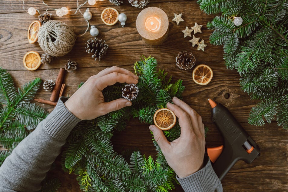 Warum kaufen, wenn man ihn auch selbst basteln kann? Unter dem Duft von grünen Zweigen, getrockneten Orangen, Zimt und Nelke ist man in Windeseile mit der Handarbeit fertig und kann sich an seinem neuen, selbstgemachten Weihnachtskranz erfreuen. (Symbolbild)