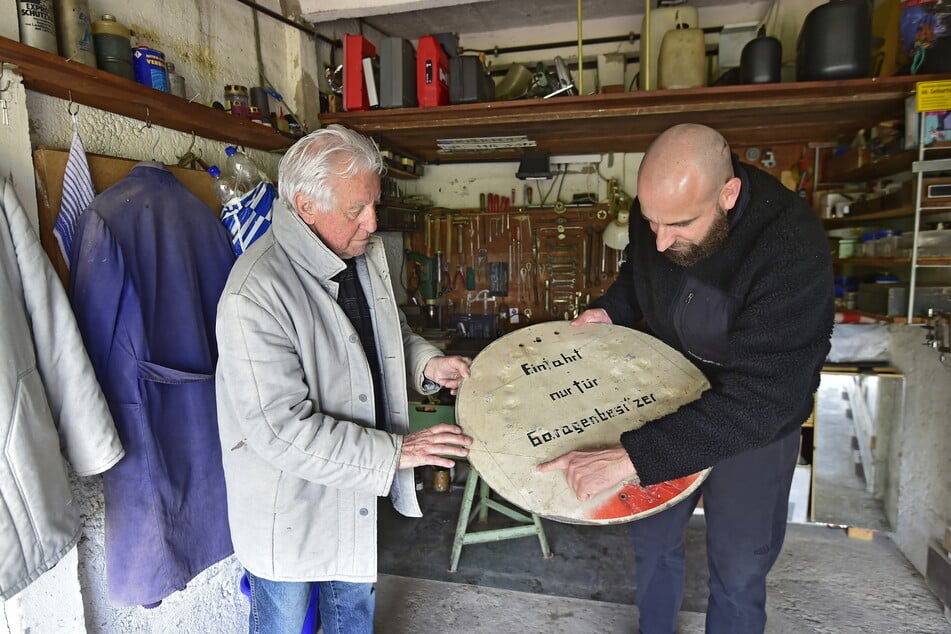 Garagenbesitzer Peter Ekrowski und Künstler Martin Maleschka (41, r.) mit einem Hinweisschild aus einer Garage.