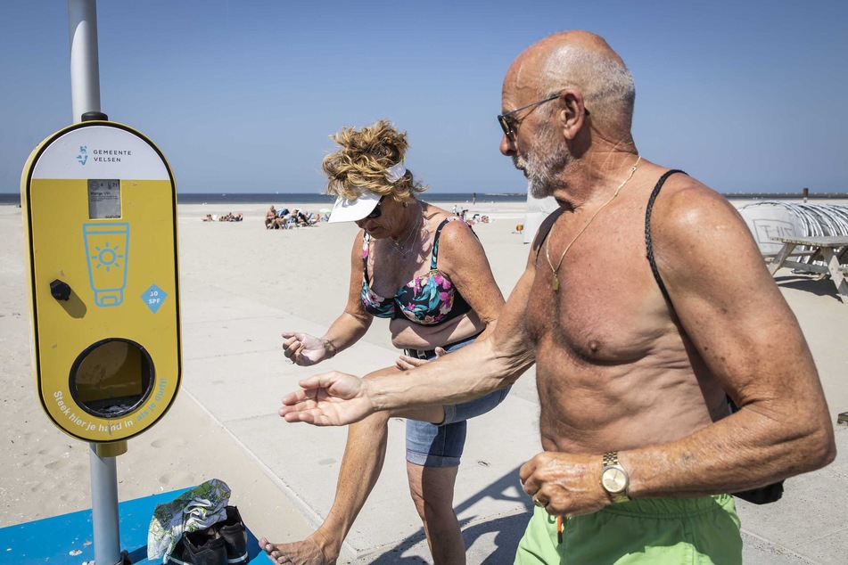 Ein Spender mit kostenlosem Sonnenschutz steht an einem Strand, um Besucher vor Sonnenbrand zu schützen. In den Niederlanden können Menschen in diesem Sommer an Hunderten Orten kostenlos Sonnencreme erhalten.