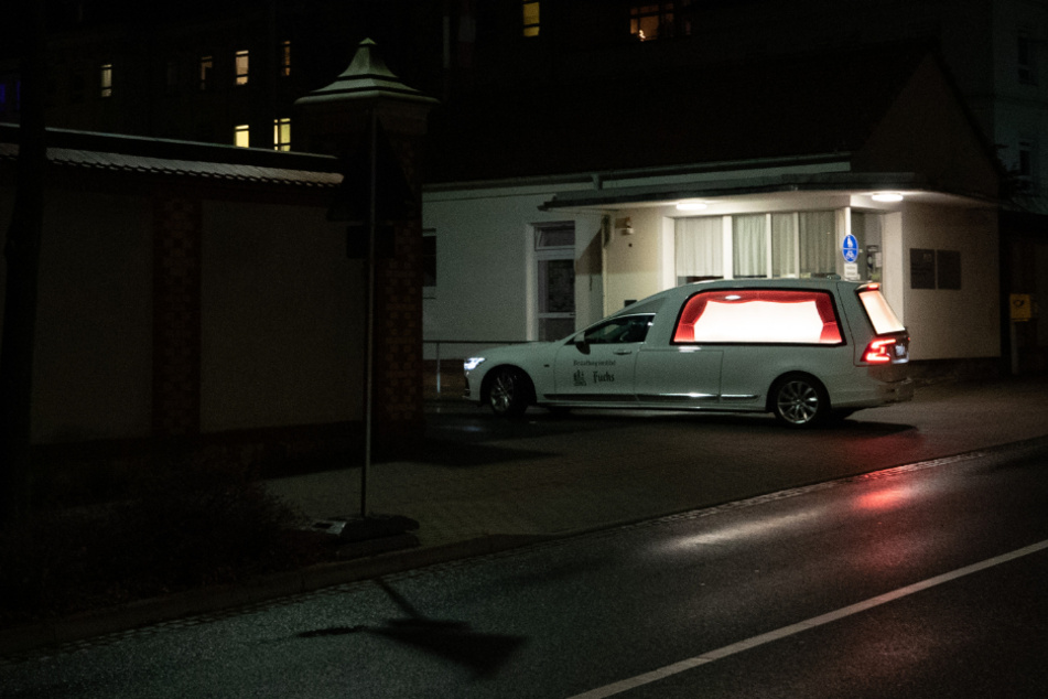 Ein Leichenwagen fährt am Abend in die Einfahrt des Klinikum Oberlausitz Bergland.