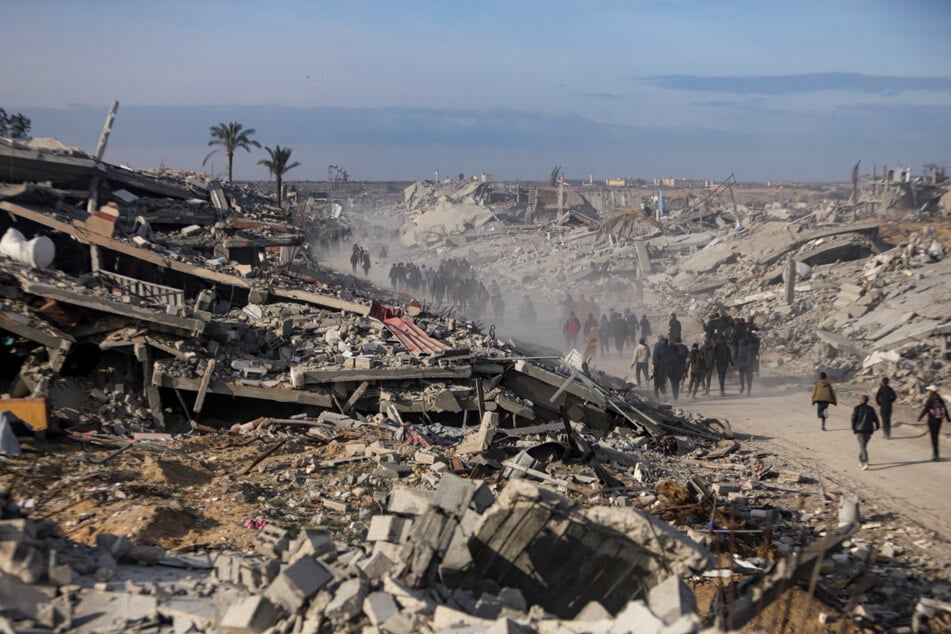 Vertriebene Palästinenser verlassen Teile von Chan Yunis auf dem Weg durch Trümmer zurück in ihre Häuser in Rafah.