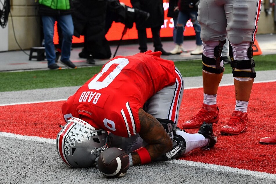 Kamryn Babb of the Ohio State Buckeyes drops to his knees after scoring his first career touchdown as a graduate player during the fourth quarter of the game against the Indiana Hoosiers at the Horse Shoe.