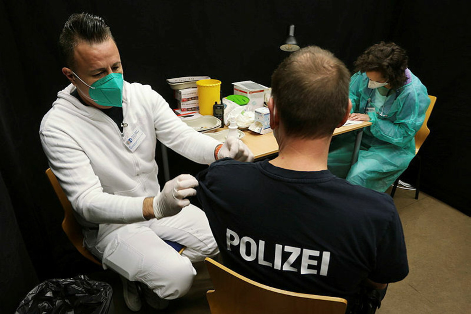 Ein Polizist holt sich seine Corona-Impfung ab. Der Hauptpersonalrat der sächsischen Polizei spricht sich für eine Duldungspflicht wie bei der Bundeswehr aus.