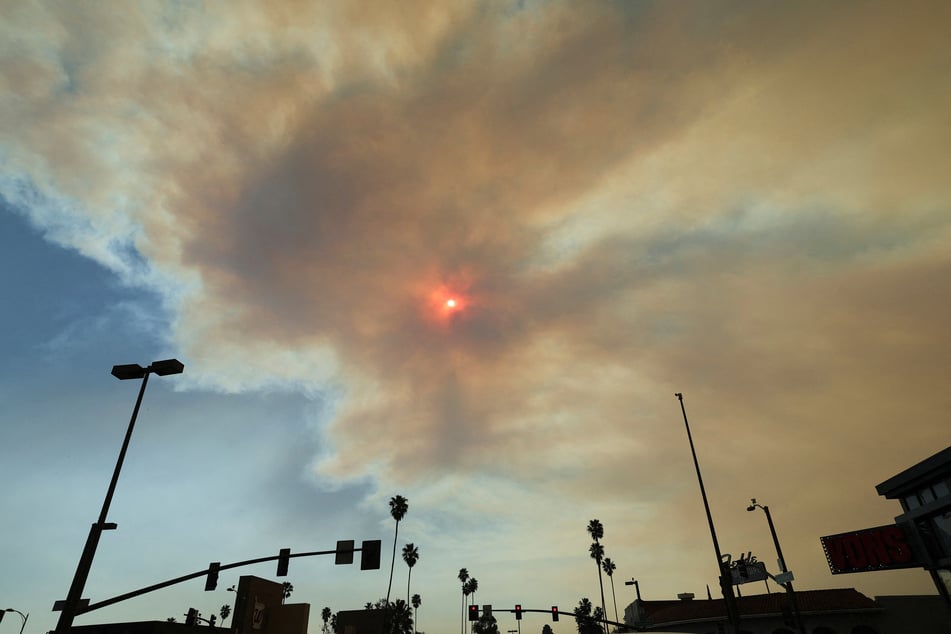 The sun is visible through smoke after the Eaton Fire tore through a neighborhood in Pasadena, California, on January 9, 2025.