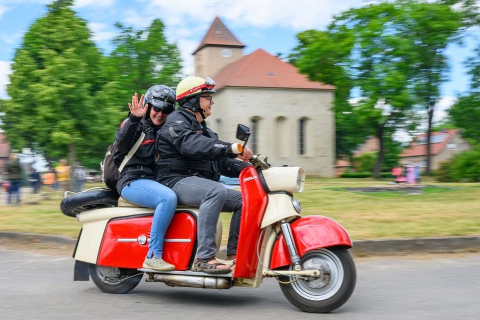 Teilnehmer fahren mit einem DDR-Roller vom Typ Troll zum Simson-Gottesdienst.