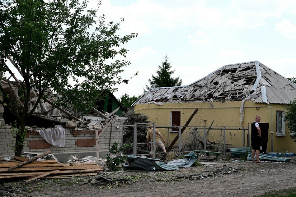 Ein Mann steht neben seinem von russischen Raketen zerstörtem Haus.