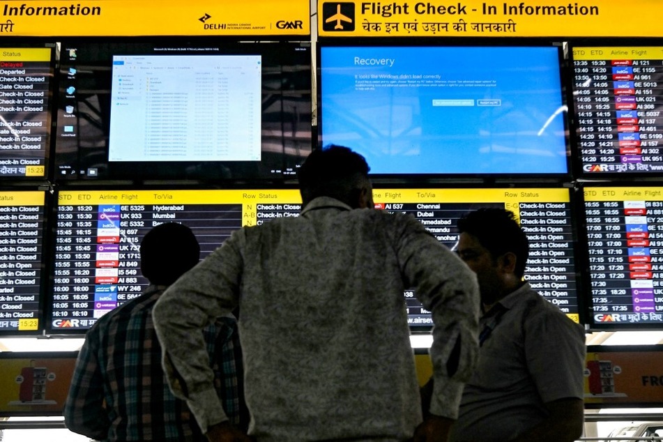 Display screens showing information on flights reflect error messages amid a global IT outage at the Indira Gandhi International Airport in New Delhi.