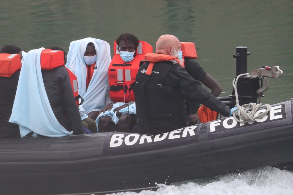 Gerettete Männer sitzen in einem Schlauchboot.