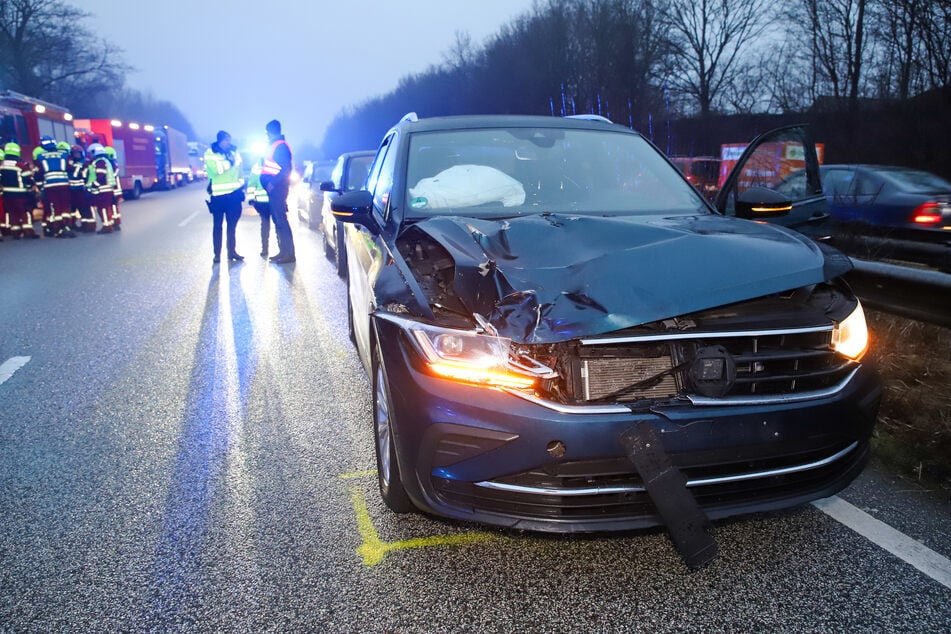 Einsatzkräfte von Polizei und Feuerwehr stehen an der Unfallstelle auf der A23.