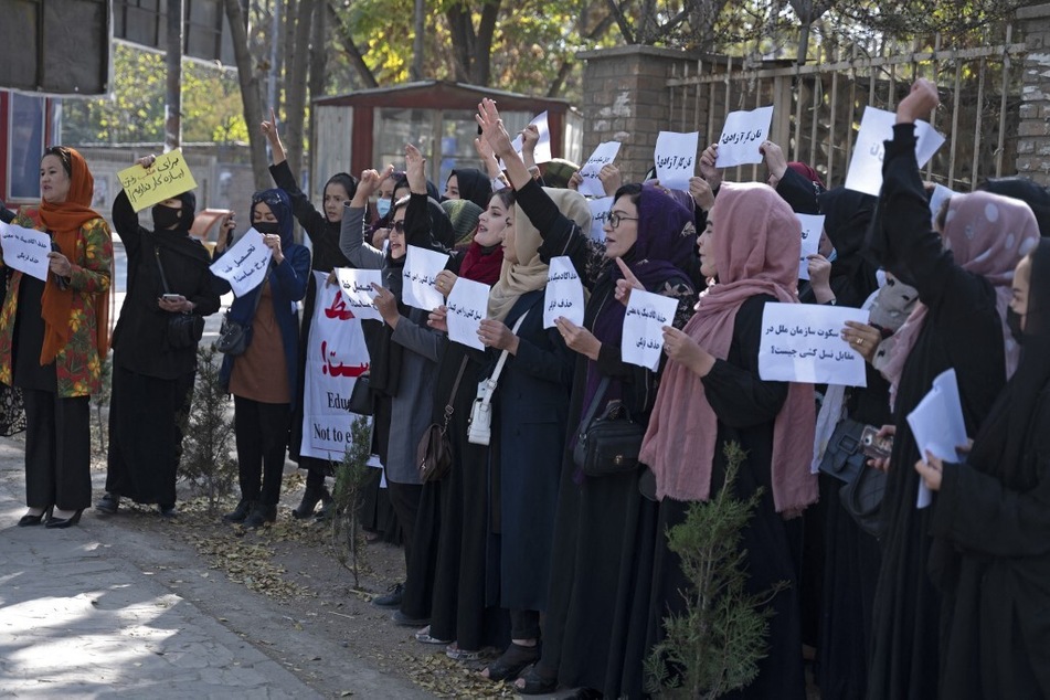 Afghan women hold signs during a protest in front of Kabul University on October 18, 2022.