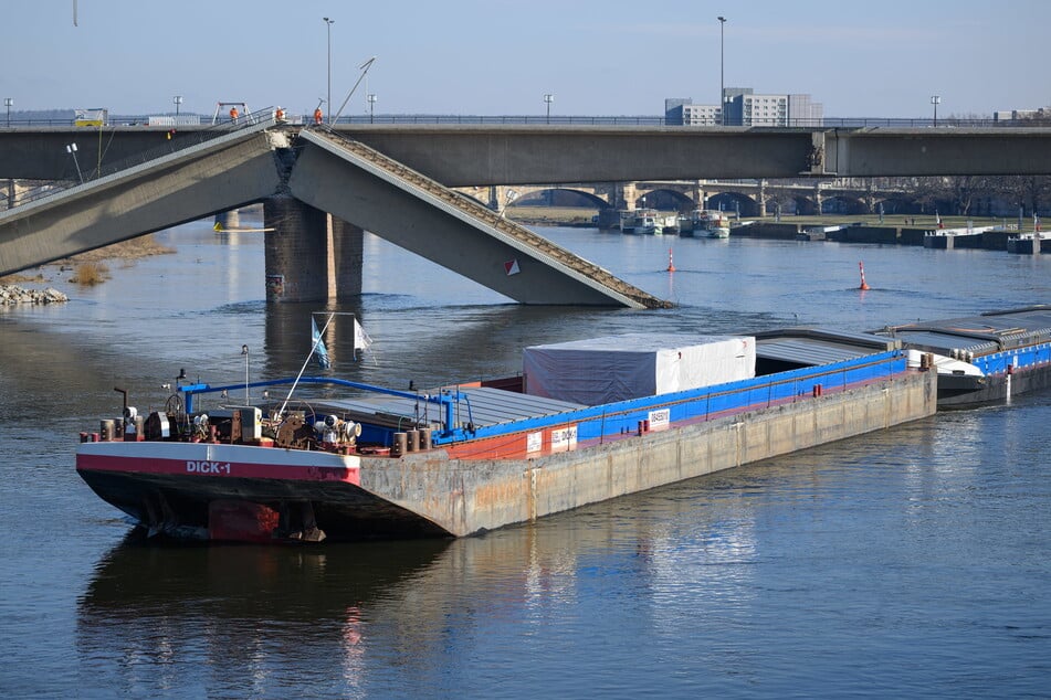 Ein Frachtschiff aus Tschechien 2025 bei der Fahrt unter der teileingestürzten Carolabrücke.
