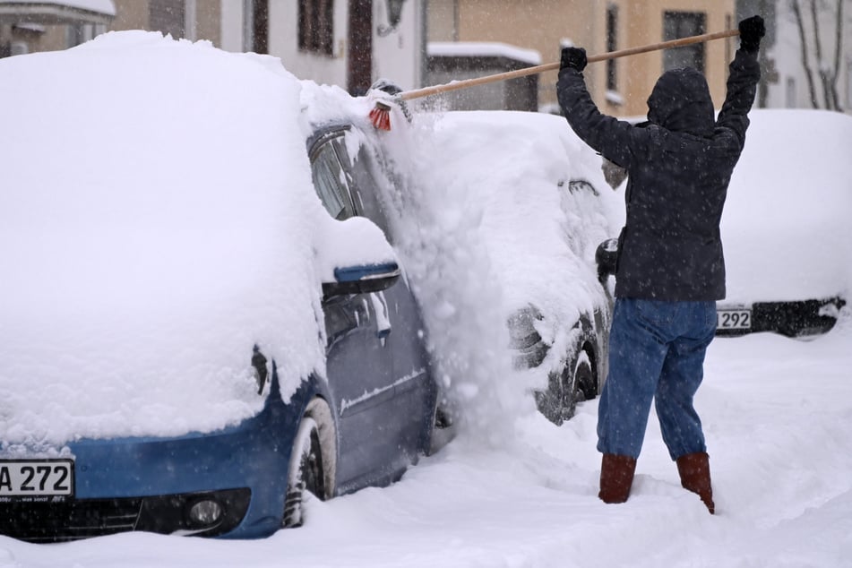 In Kassel musste eine Frau ihr Auto von den vielen Schneemassen befreien.