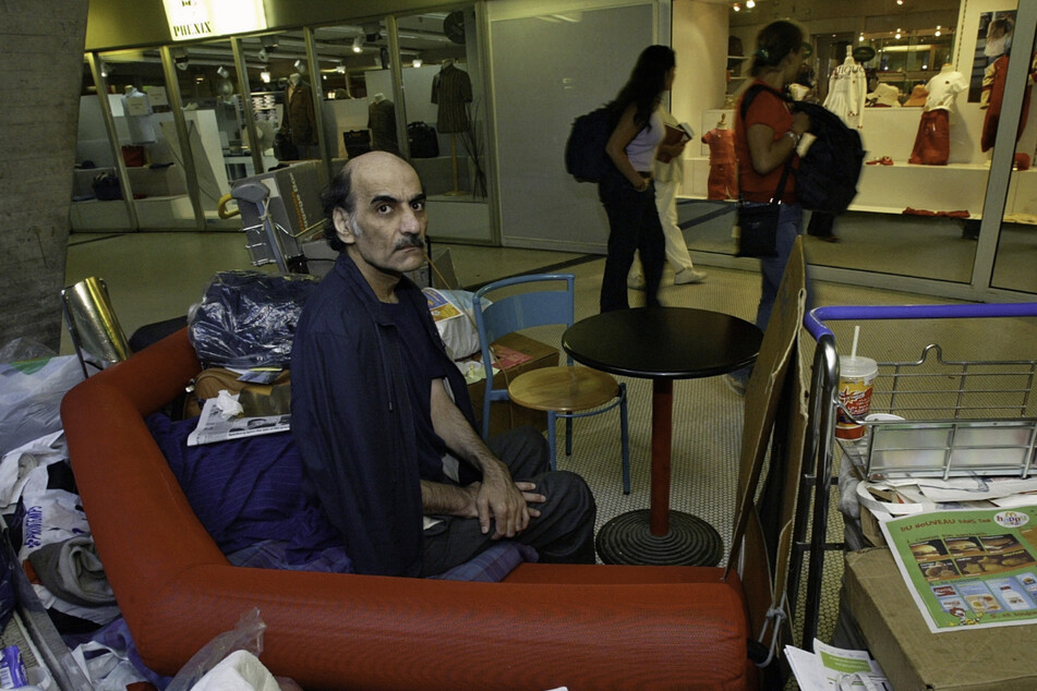 Mehran Karimi Nasseri sitzt zwischen seinen Habseligkeiten im Terminal 1 des Flughafens Roissy Charles De Gaulle. (Archivbild)