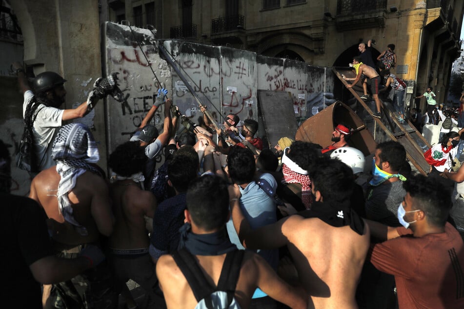 Demonstranten versuchen bei einem regierungskritischen Protest, die Betonmauer zu entfernen, die von den Sicherheitskräften errichtet wurde, um die Demonstranten daran zu hindern, das Parlamentsgebäude zu erreichen.