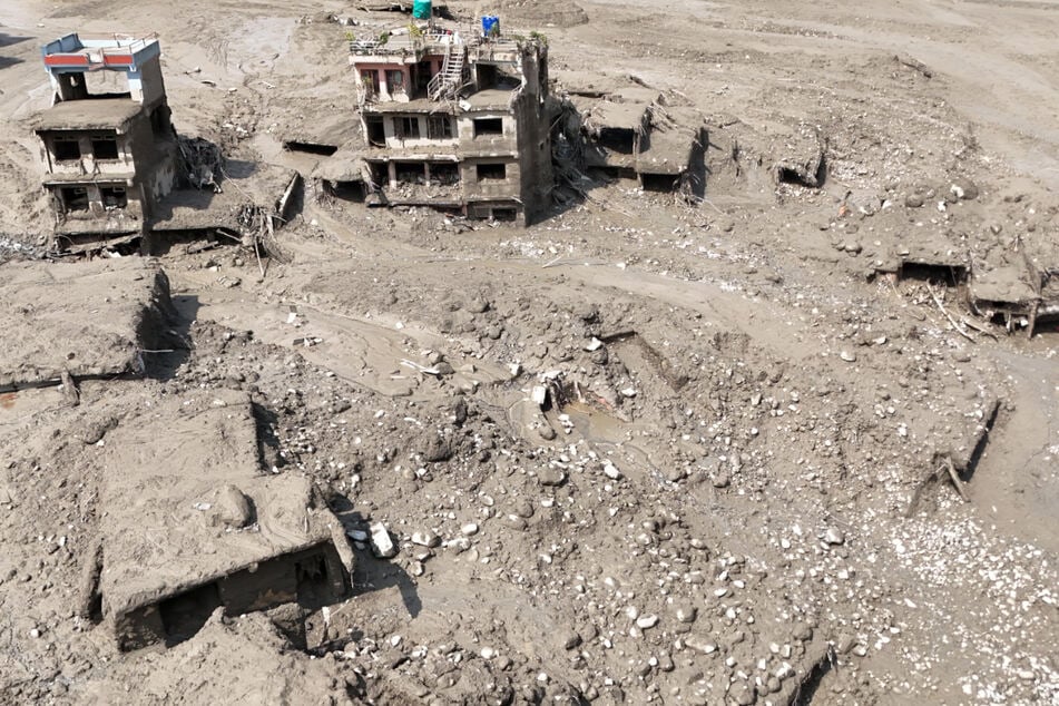 Beschädigte Gebäude und Infrastruktur entlang des angeschwollenen Trishuli-Flusses.