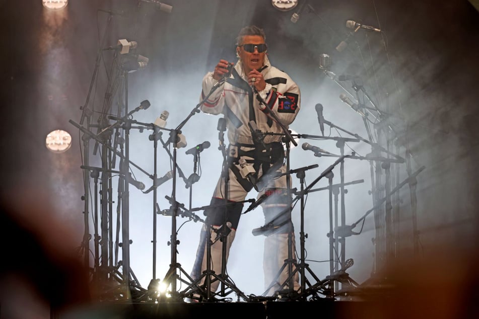 Umzingelt von Mikrofonen, im weißen Raumanzug betritt Robbie Williams (51) am Mittwoch die Bühne der Leipziger Red Bull Arena.