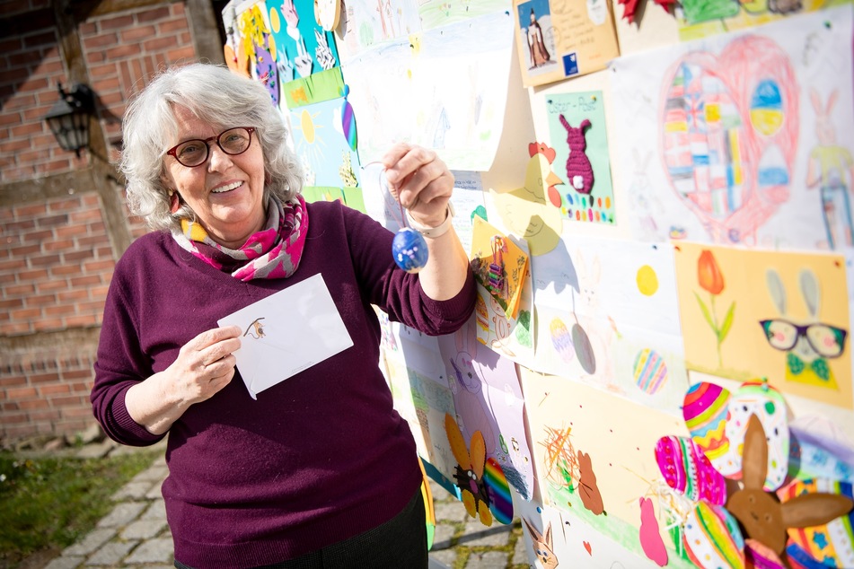 Doris Kröger, die Leiterin vom Osterpostamt, steht vor einer Stellwand mit Briefen, die Kinder für den Osterhasen Hanni Hase geschrieben haben.