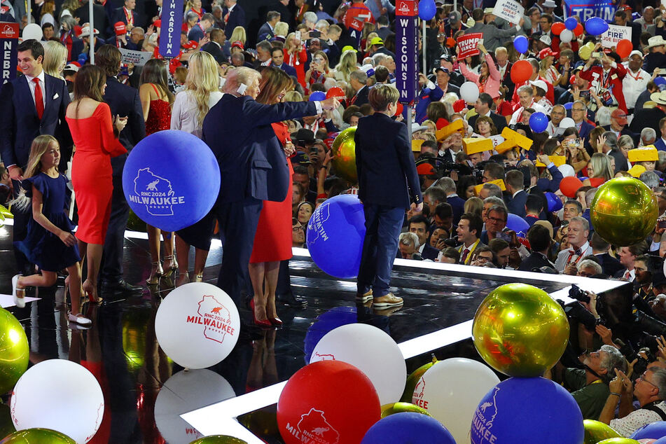 Donald Trump and his family face the crowd as balloons fall following his speech on Day 4 of the 2024 Republican National Convention.