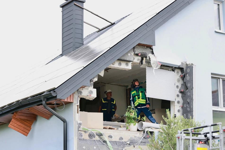 Einsatzkräfte des Technischen Hilfswerks begutachten die Schäden an der Fassade.