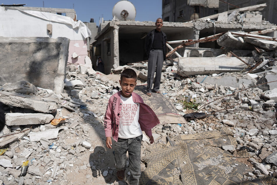 A boy walks amid debris following Israeli bombardment in Nuseirat, central Gaza, on April 12.