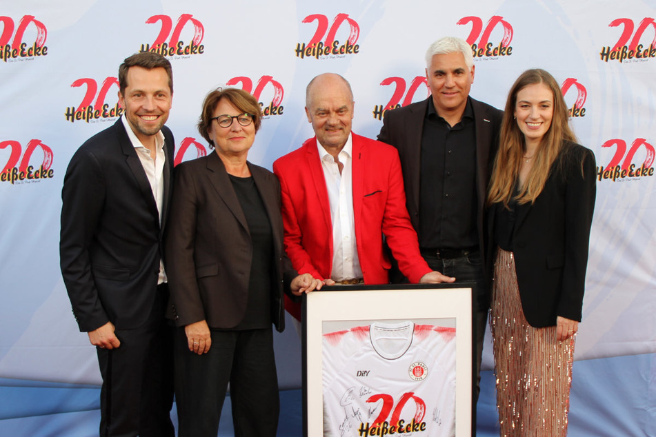 Andreas Bornemann (52) hat Theatermacher Corny Littmann (70, m.) und Tivoli-Geschäftsführerin Tessa Aust (r.) ein "Heiße Ecke"-Trikot mit Unterschriften der Spieler überreicht.