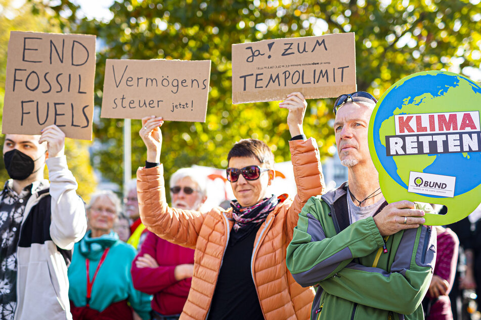 Die Schriftzüge "End fossil fuels", "Vermögenssteur jetzt", "Ja zum Tempolimit" und "Klima retten" sind auf Plakaten von Demonstranten zu lesen.