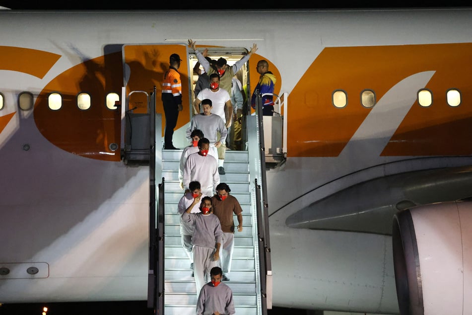 Venezuelan migrants deported from US' Guantanamo Bay Naval Base exit a Conviasa Airlines plane as they arrive at Simon Bolivar International Airport in Maiquetia on February 20, 2025.