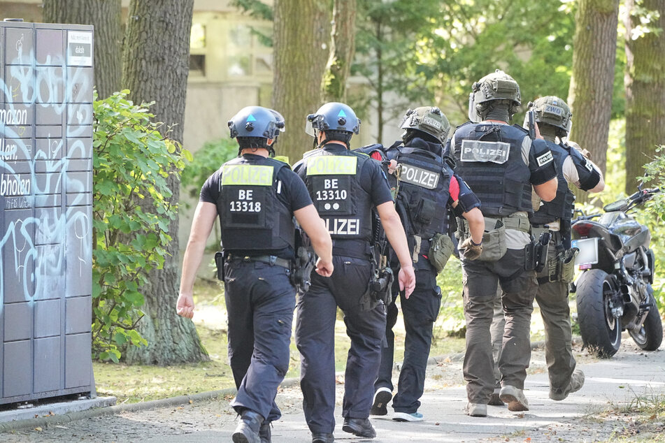 Schwer bewaffnete Polizisten rücken zum Mehrfamilienhaus aus.