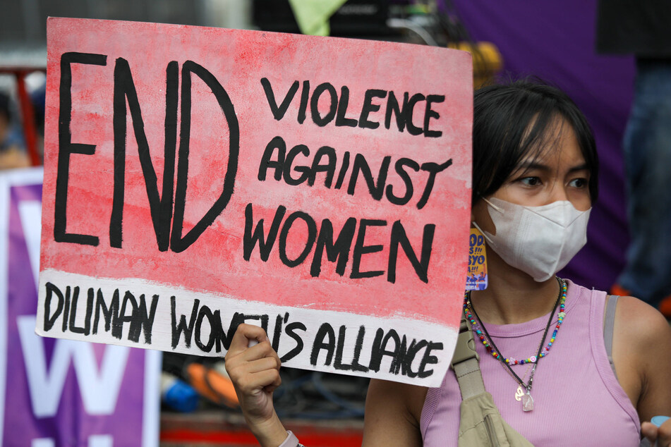 A woman holds a sign as protesters rally to mark International Women s Day in Manila, Philippines on March 8, 2023.