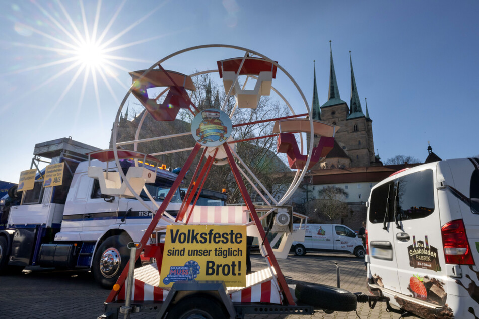 "Volksfeste sind unser täglich Brot" steht auf einem Plakat an einem der Fahrzeuge. Der Autokorso startete am Erfurter Domplatz.