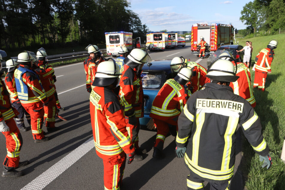 Feuerwehrleute haben ein Unfall-Fahrzeug auf den Standstreifen geschoben.
