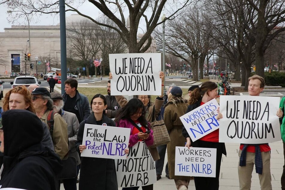 Participants raise signs reading "Workers Need the NLRB" and "We Need a Quorum" during an AFL-CIO rally in support of Gwynne Wilcox.