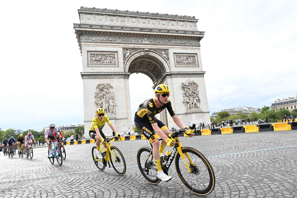 Nathan Van Hooydonck (27, r.) bei der Schlussetappe in Paris bei der diesjährigen Tour de France vor Sieger Jonas Vingegaard (26, l.).
