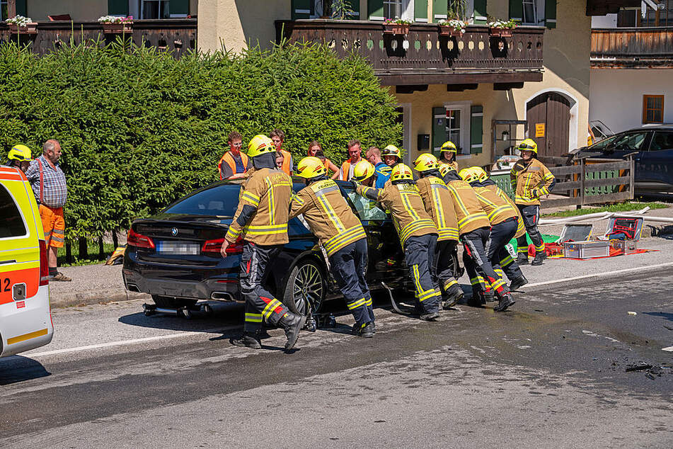 Die Feuerwehr schiebt den BMW von der Fahrbahn.