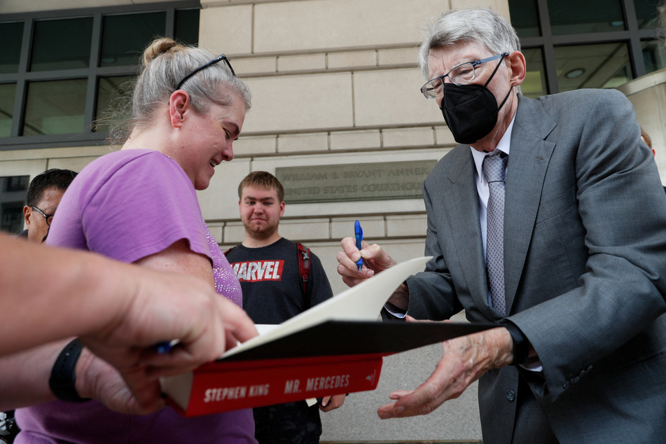 Stephen King gives autographs as he leaves the US District Court.