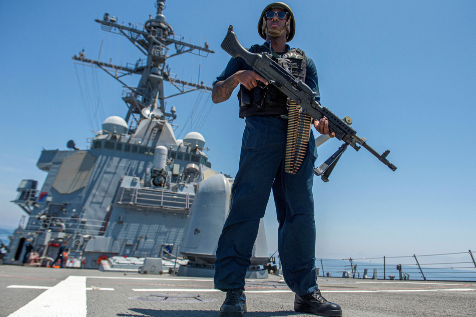 Master-At-Arms 1st Class Julius Earl stands watch with an M240B machine gun on the fo'c'scle of the guided-missile destroyer USS Paul Hamilton (DDG 60), deployed to during a Strait of Hormuz transit.