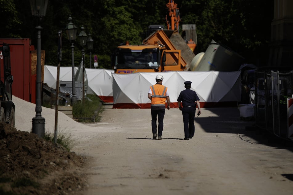 Einsatzkräfte gehen in Richtung der Unfallstelle. Im Hintergrund ist der Lkw mit dem umgestürzten Bauteil zu sehen.