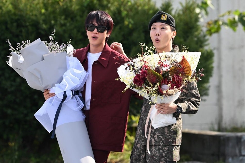 J-hope (r.) is greeted by fellow BTS member Jin after being discharged from his mandatory military service.