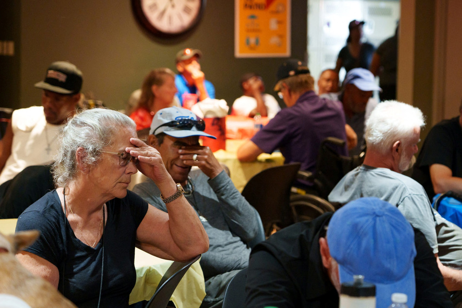 People sit in a crowded room at Justa Center, one of the Valley's many cooling centers, during a heat wave in Phoenix, Arizona.